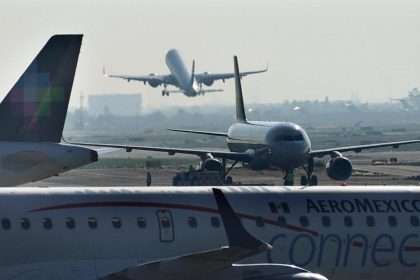 Other Passengers Help A Man Open The Emergency Exit And